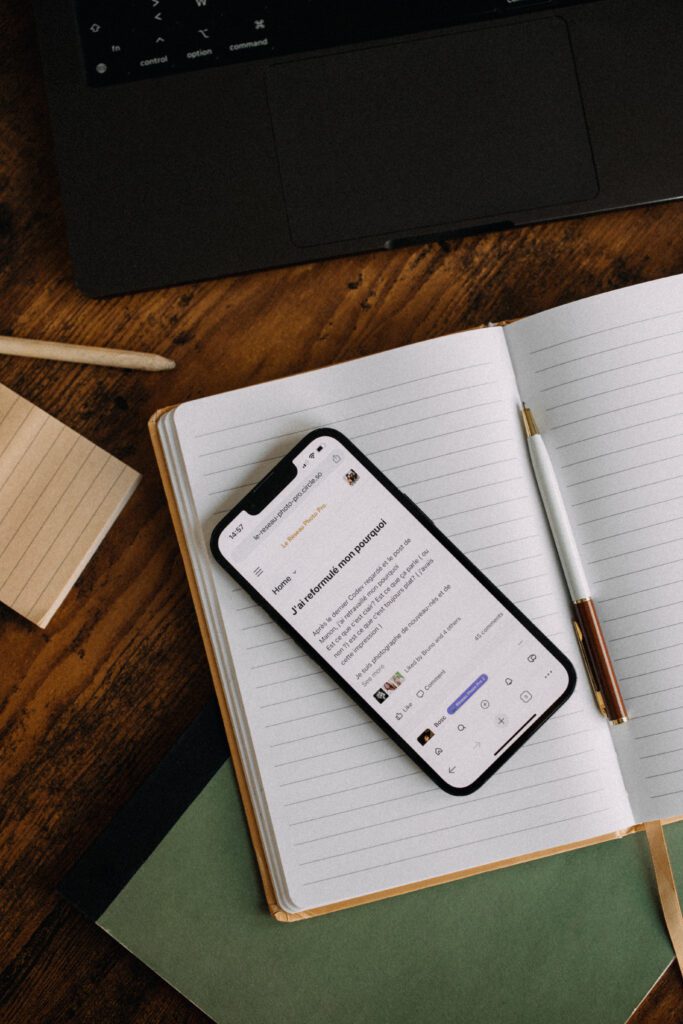 Accueil 18 Application mobile réseau entraide photographe sur carnet avec stylo et ordinateur sur bureau